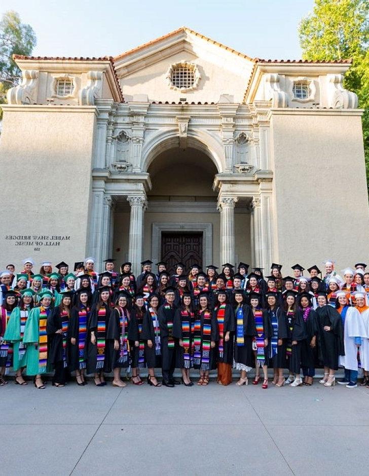 members of the chicano latino student union pose in their graduation gowns